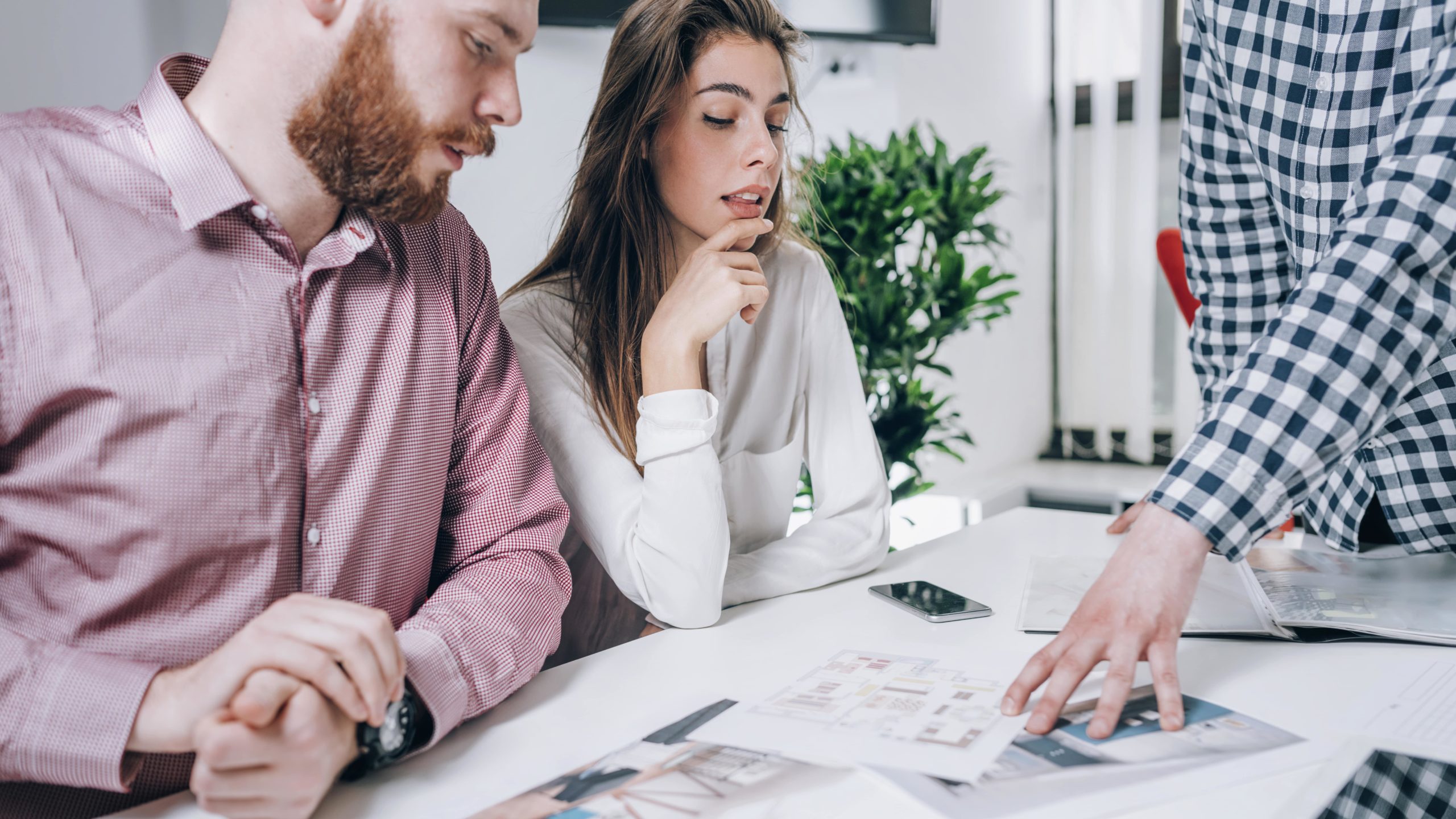 Pareja en agencia inmobiliaria hablando con bienes raíces